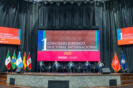 Escenario del 1er Congreso Jurídico Doctoral Internacional con la pantalla del evento y las banderas de los países participantes
