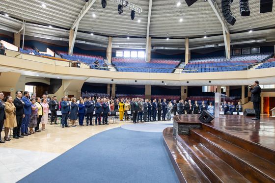 Asistentes de pie durante la ceremonia inaugural