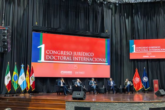 Panel de ponentes sobre el escenario del congreso